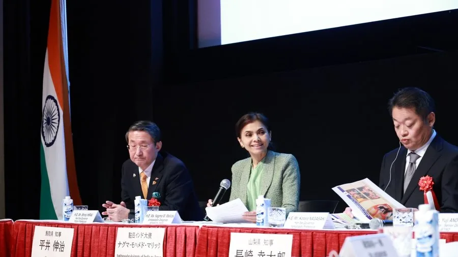 India's Ambassador to Japan speaking on a panel beside Japanese governors, with the Indian flag behind.